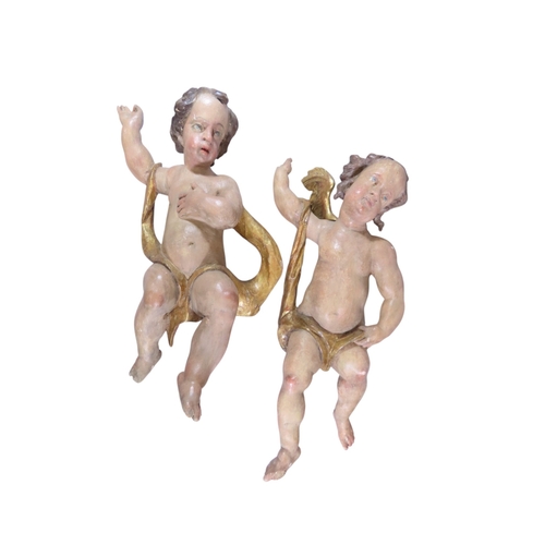 37 - A large and impressive associated pair of carved and painted limewood putti, likely south German / N... 