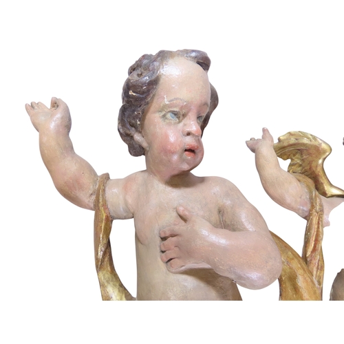 37 - A large and impressive associated pair of carved and painted limewood putti, likely south German / N... 