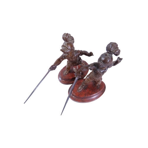 9 - A pair of 19th century continental bronze figures, humorous opposing dueling infants presented with ... 