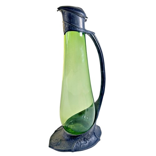 Attributed to David Veasey (in the style of Archibald Knox) for Liberty & Co, a Tudric pewter and green glass claret jug / ewer with hinged thumb-press cover, and integral handle over a shaped base foot, with impressed marks to underside, numbered 0263, registration number Rd.42773739 38 cm high
