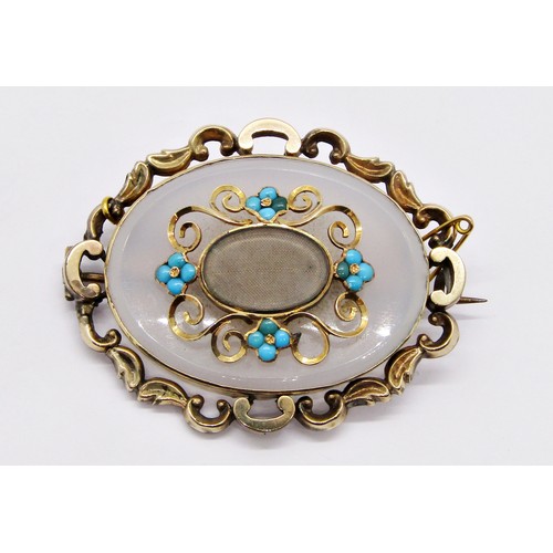 262 - An antique yellow metal mounted chalcedony brooch of oval form, with central vacant mourning apertur... 