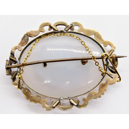 262 - An antique yellow metal mounted chalcedony brooch of oval form, with central vacant mourning apertur... 