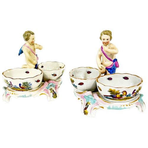 47 - A pair of 19th century Meissen double salts with cherub mounts and polychrome decoration of flowers ... 
