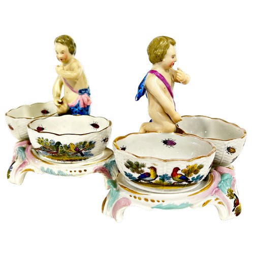 47 - A pair of 19th century Meissen double salts with cherub mounts and polychrome decoration of flowers ... 