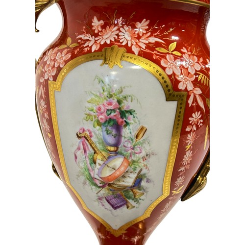 49 - A large continental porcelain lamp base with gilt handles and base, the brick red ground enclosing f... 