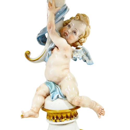 46 - A pair of Capodimonte porcelain candlesticks in the form of cherubs holding aloft a cornucopia later... 