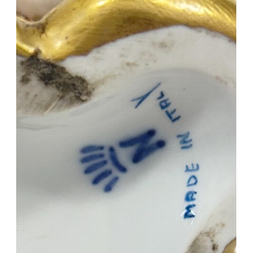 46 - A pair of Capodimonte porcelain candlesticks in the form of cherubs holding aloft a cornucopia later... 