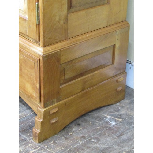 1523 - A fine quality Cotswold school fitted wardrobe in pale English walnut, the panelled frame enclosed b... 