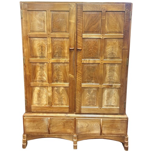 1523 - A fine quality Cotswold school fitted wardrobe in pale English walnut, the panelled frame enclosed b... 