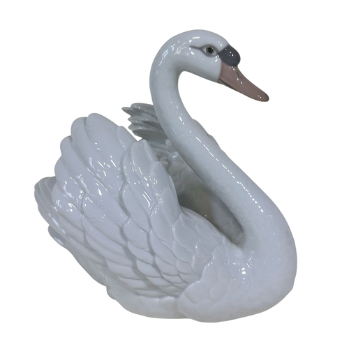 31 - A collection of Lladro, comprising: two swans, a girl at a water pump, two further geese and a bell ... 