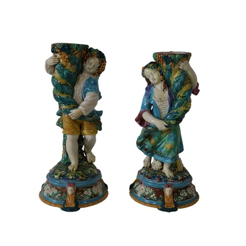 46 - A pair of 19th century Majolica comport stands, male and female characters each holding a cornucopia... 