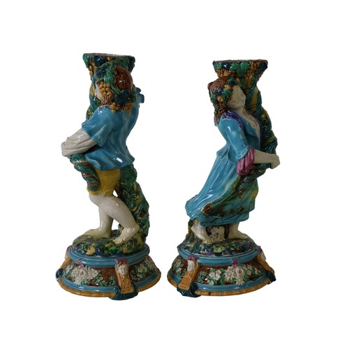 46 - A pair of 19th century Majolica comport stands, male and female characters each holding a cornucopia... 