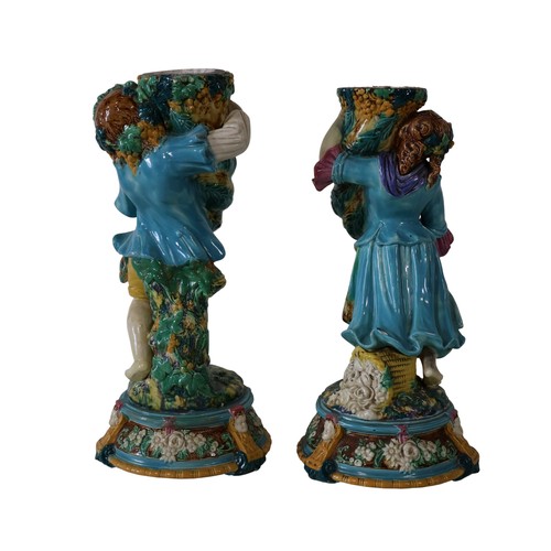 46 - A pair of 19th century Majolica comport stands, male and female characters each holding a cornucopia... 