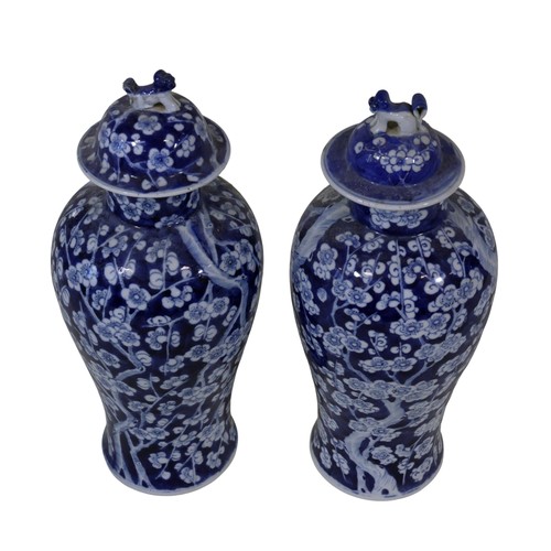 55 - A pair of Chinese blue and white porcelain prunus vases with dog finial covers, bearing apocryphal f... 