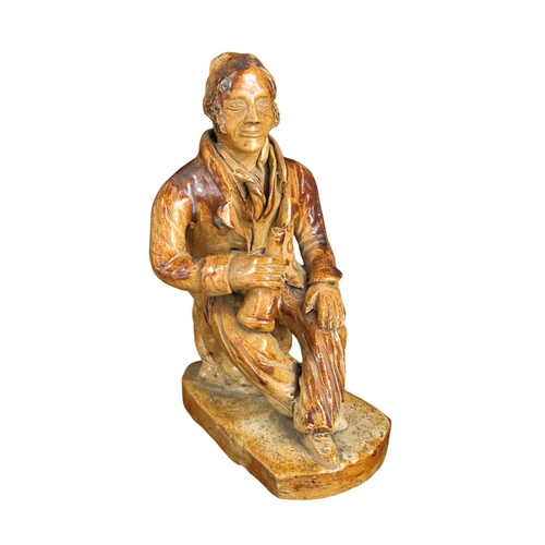257 - An early 19th C Salt glazed figure of a seated character holding a bottle 19cm High