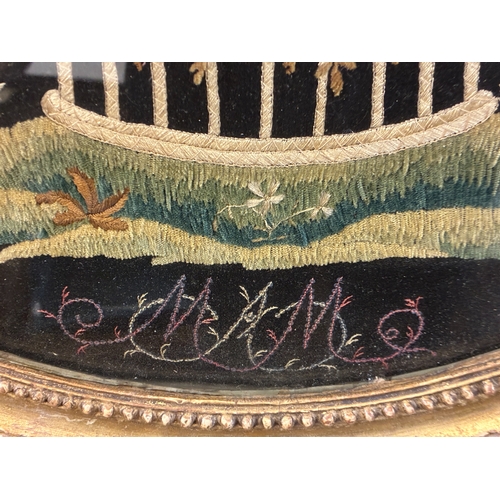 50 - A large 18th century silkwork embroidery of a basket of flowers, signed below, glazed in oval gilt f... 