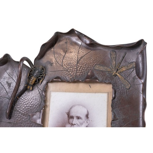 310 - An Arts and Crafts bronzed and gilt copper photograph frame, of leaf form, mounted in relief with li... 
