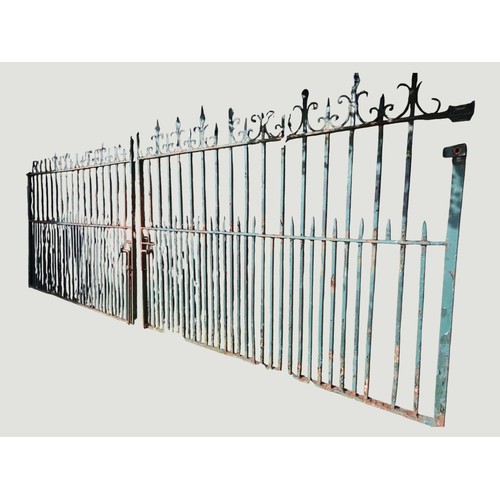 A pair of heavy gauge green painted and weathered iron entrance gates ...