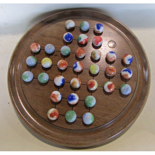 687 - A large walnut solitaire board with polished glass marbles, 33 cm diameter