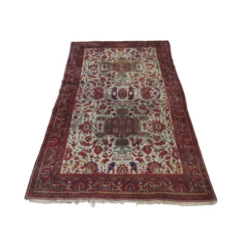 A Persian rug with a white ground field with floral detail within ...