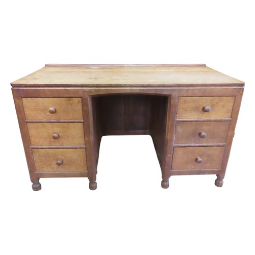 A mouseman kneehole desk in oak with adze and chamfered detail within a panelled frame, fitted with six drawers and carved mouse insignia, 78 cm (full height) x 137 cm x 68 cm