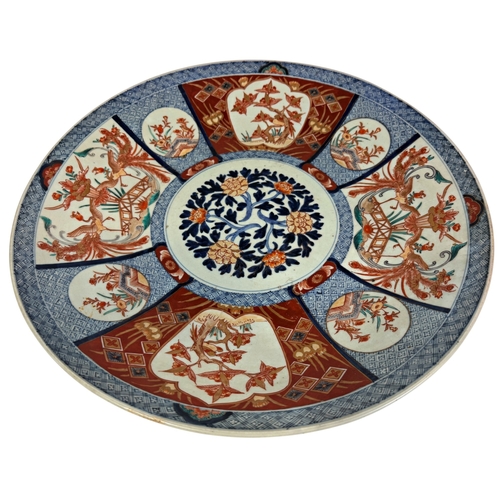 55 - A large 19th century Imari charger with a repeating floral and other detail. 45cm in diameter.