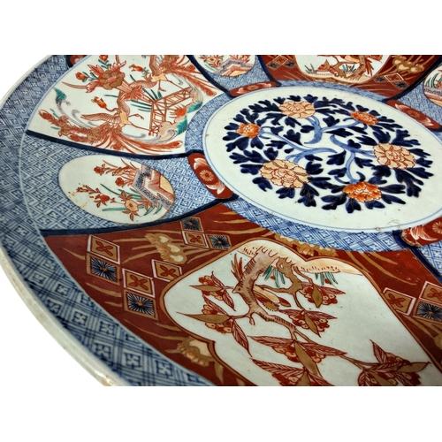 55 - A large 19th century Imari charger with a repeating floral and other detail. 45cm in diameter.
