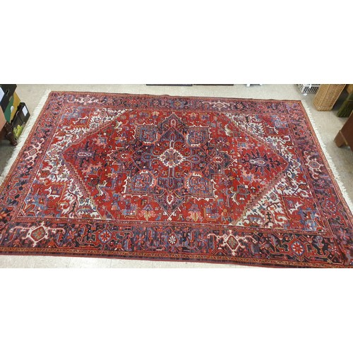 633a - All Wool, Heriz Floor Rug with geometric pattern design on a red ground, c.3m x 2m