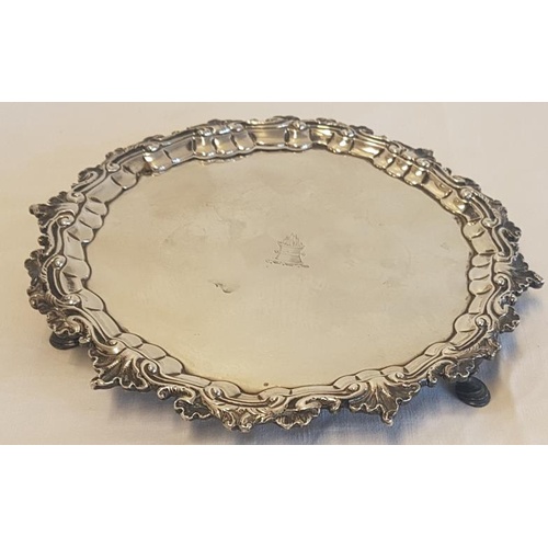 263 - Irish Silver Dish with profusely decorated border around a barrel of flames and raised on three hoov... 