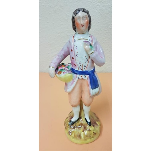 413 - Early 19th Century Staffordshire Figure. A gentleman carrying a basket of fruit. Grazing to glaze as... 