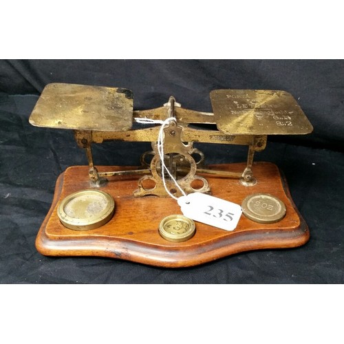 235 - 19th Century brass postal scales on a mahogany base with three brass weights in used condition