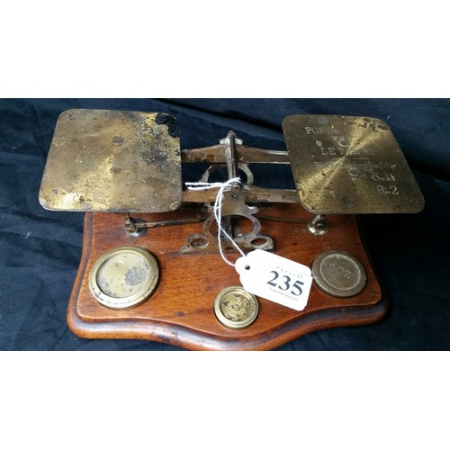 235 - 19th Century brass postal scales on a mahogany base with three brass weights in used condition