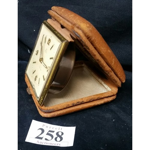 258 - A Vintage Smiths De Lux 8-day travel clock in a tan brown leather case. The clock is working since w... 