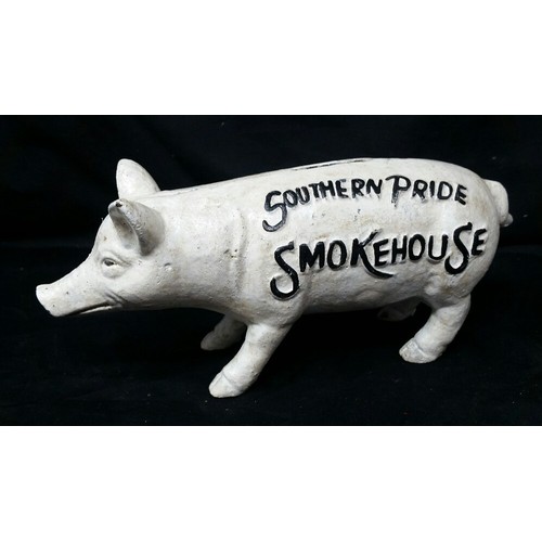 259 - A heavy cast iron pig moneybox. Southern Pride Smoke House. 8 inches long x 3.5 inches high. An anti... 