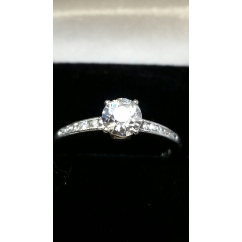 292 - A good platinum solitaire diamond ring flanked by diamond encrusted shoulders. Central diamond appro... 