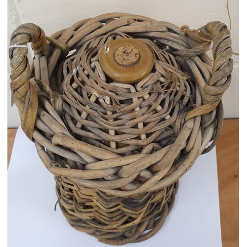 412 - Vintage whiskey jug in wicker basket with cork stopper.