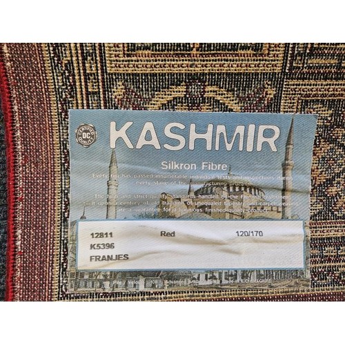 457 - Kashmir Silk Fibre Floor Rug, with a band of geometric and floral patterns and central crest on a de... 