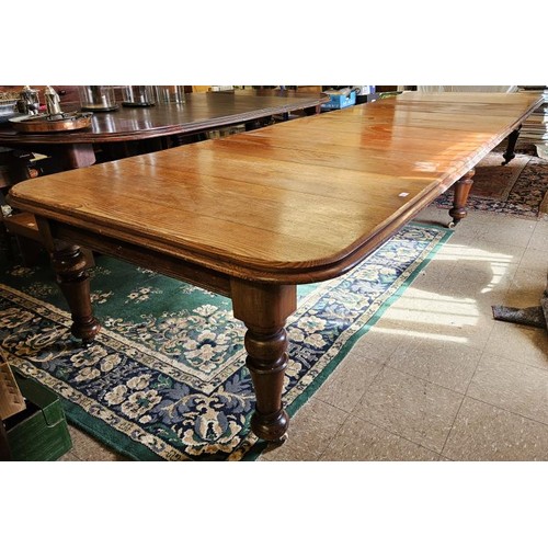 Incredible Victorian Pitch Pine Extending Dining/Boardroom Table. The top with moulded edge above six turned legs on brass toes with original ceramic casters. Measures c.6ft x 4ft6in closed and with all 7 leaves in place it measures c.14ft6in x 4ft6in