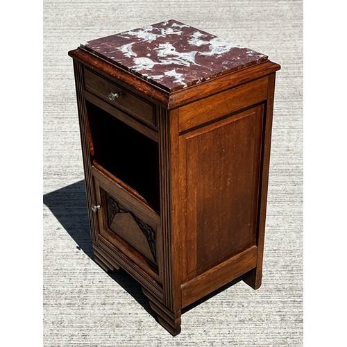 40 - A Marble topped storage unit of utilitarian design with carved decoration to the door and a lined cu... 