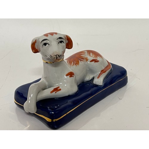 249 - Staffordshire greyhound figurine of a recumbent hound at rest on a blue cushion making the plinth fo... 