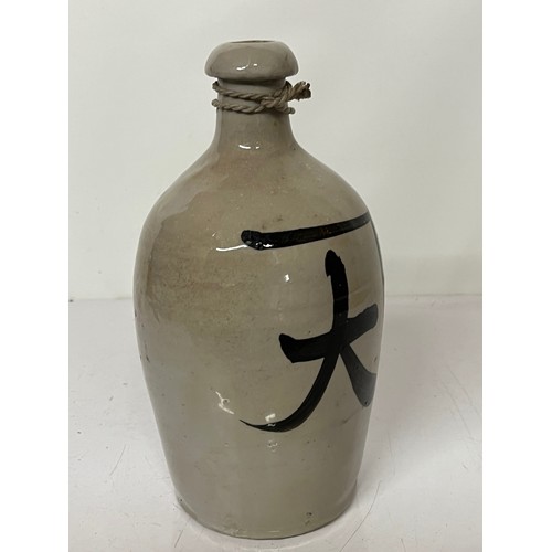 331 - Oriental stoneware Saki bottle, glazed lettering to front and rear. 10 inches high.

This lot is ava... 