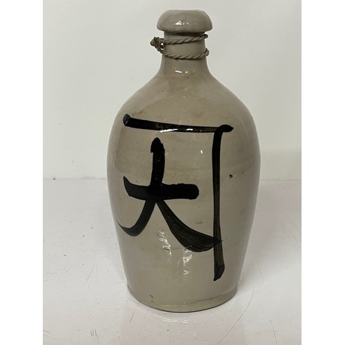 331 - Oriental stoneware Saki bottle, glazed lettering to front and rear. 10 inches high.

This lot is ava... 