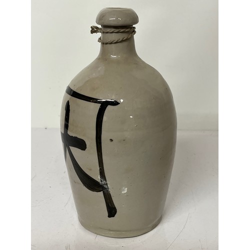 331 - Oriental stoneware Saki bottle, glazed lettering to front and rear. 10 inches high.

This lot is ava... 