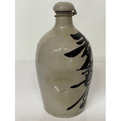 331 - Oriental stoneware Saki bottle, glazed lettering to front and rear. 10 inches high.

This lot is ava... 