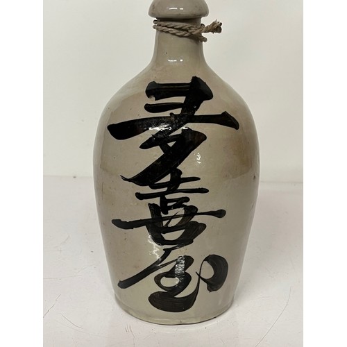 331 - Oriental stoneware Saki bottle, glazed lettering to front and rear. 10 inches high.

This lot is ava... 