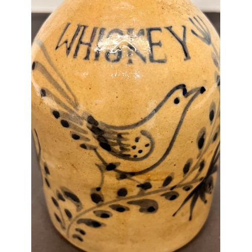 147 - Stoneware Whiskey flagon decorated with a bird in a floral composition.

15 cm high overall.

This l... 