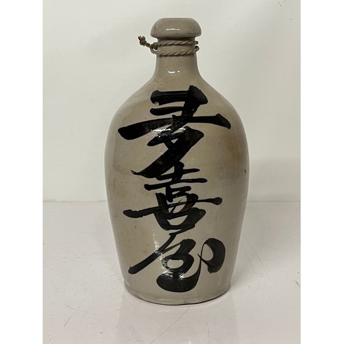 329 - Oriental stoneware Saki bottle, glazed lettering to front and rear. 10 inches high.

This lot is ava... 