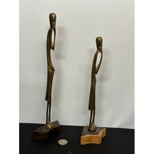 17 - A pair of contemporary cast brass African figures mounted on wooden stands. 30 cm and 35 cm tall .

... 