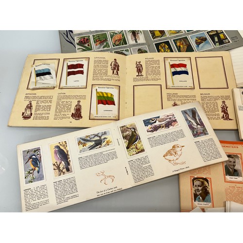 117 - Ephemera, cigarette cards and trade cards, a collection in seven albums and a packet as shown.

This... 