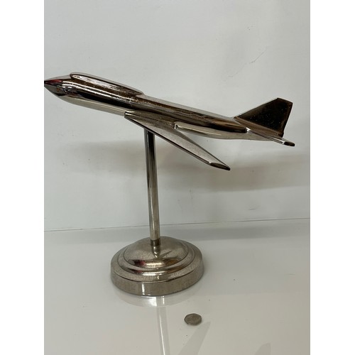 179 - A stylised chrome plated aviation desk piece, a large jet age model of plane with a raised cockpit s... 